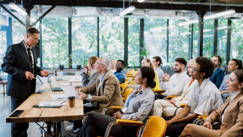 Cinematic view of a conference with lush greenery in the background.