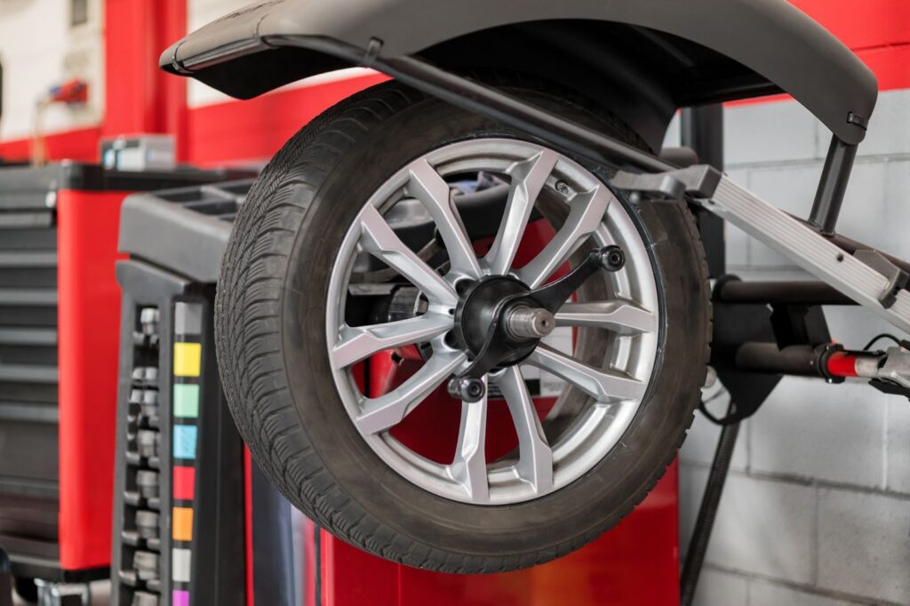 A wheel mounted on a computerized tire balancing machine in an automotive workshop