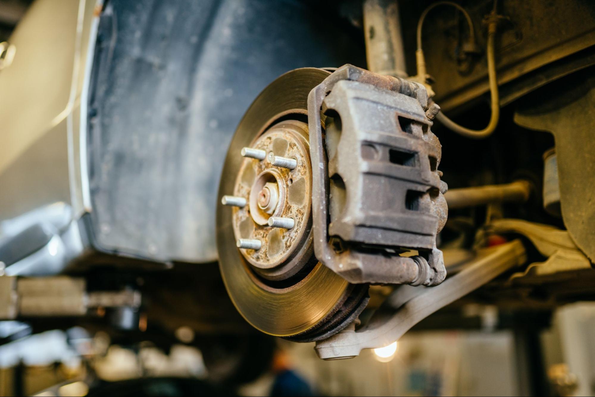 Technician using specialized equipment to replace a brake disc rotor in a professional car repair shop